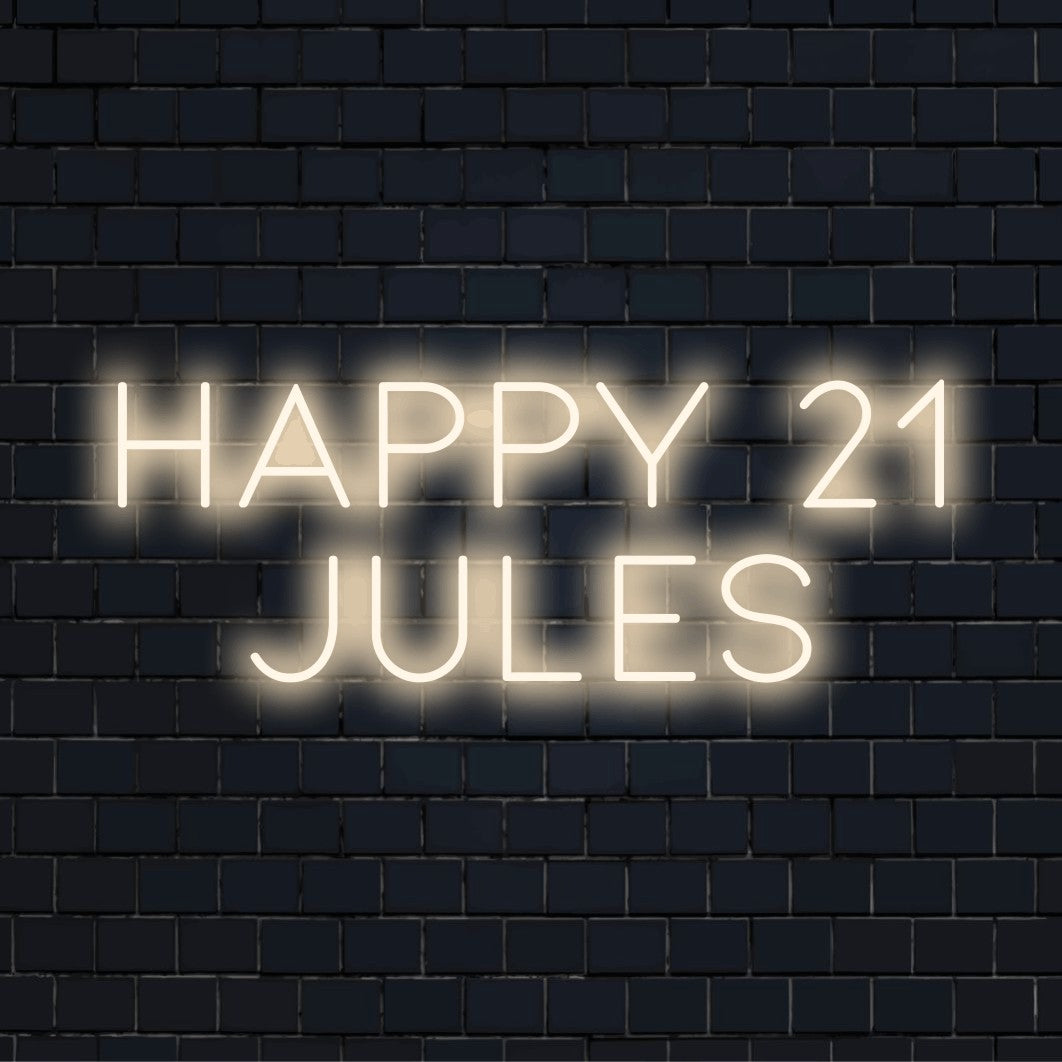 Happy 21 Jules Custom Name Neon Sign, bright neon glow against black brick wall