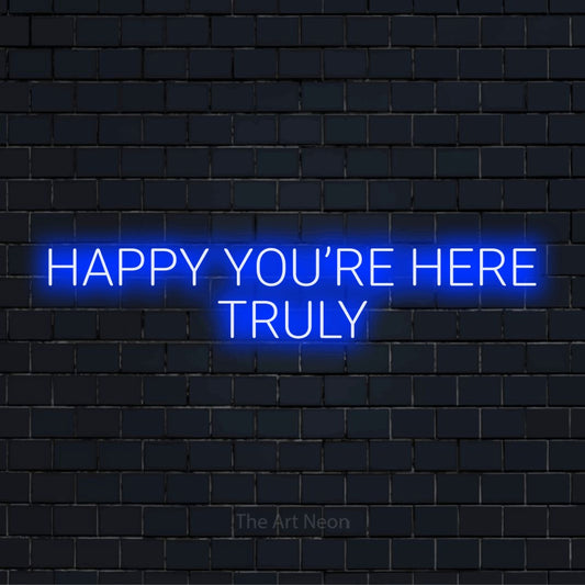 "Happy You’re Here Truly" LED neon sign on a black brick wall
