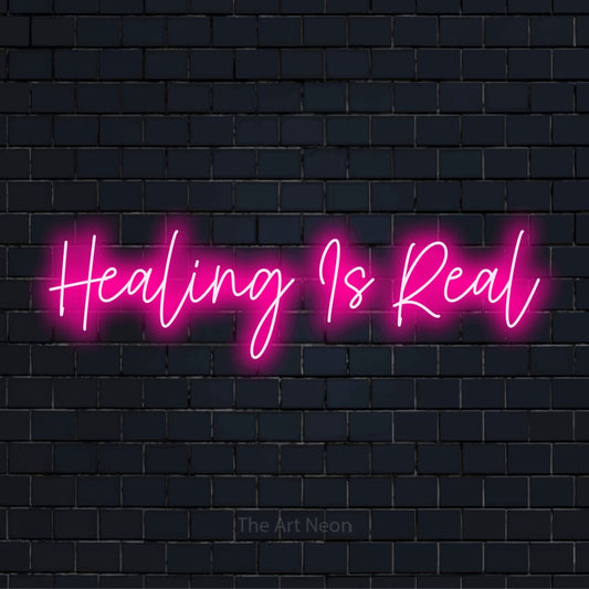"Healing Is Real" LED neon sign on a black brick wall