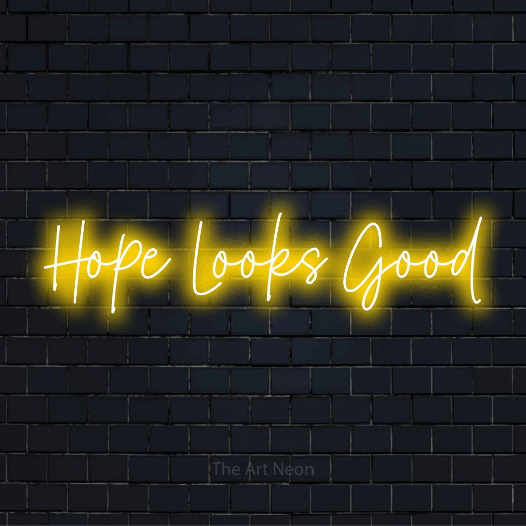 "Hope Looks Good" glowing LED neon sign on a black brick wall