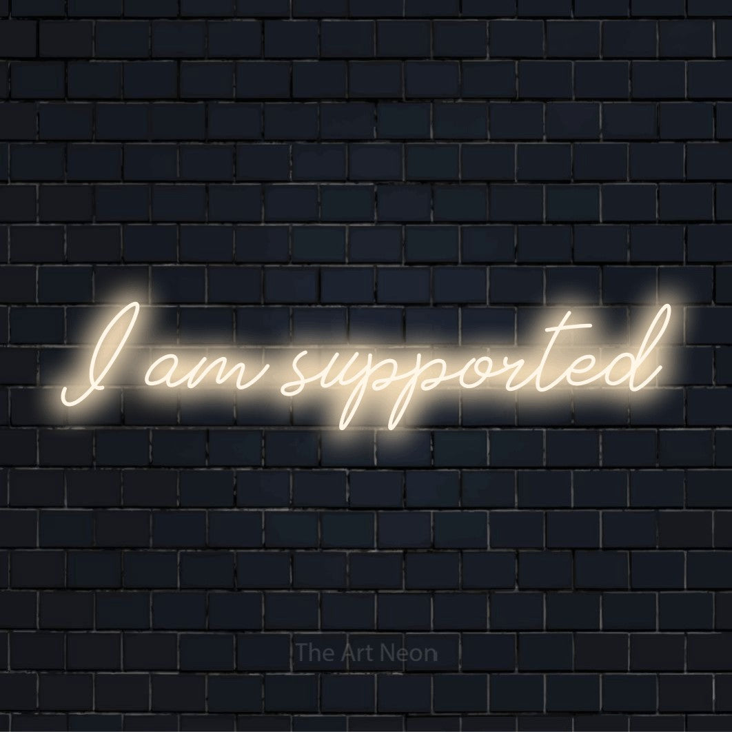 "I Am Supported" neon text design on a black brick wall
