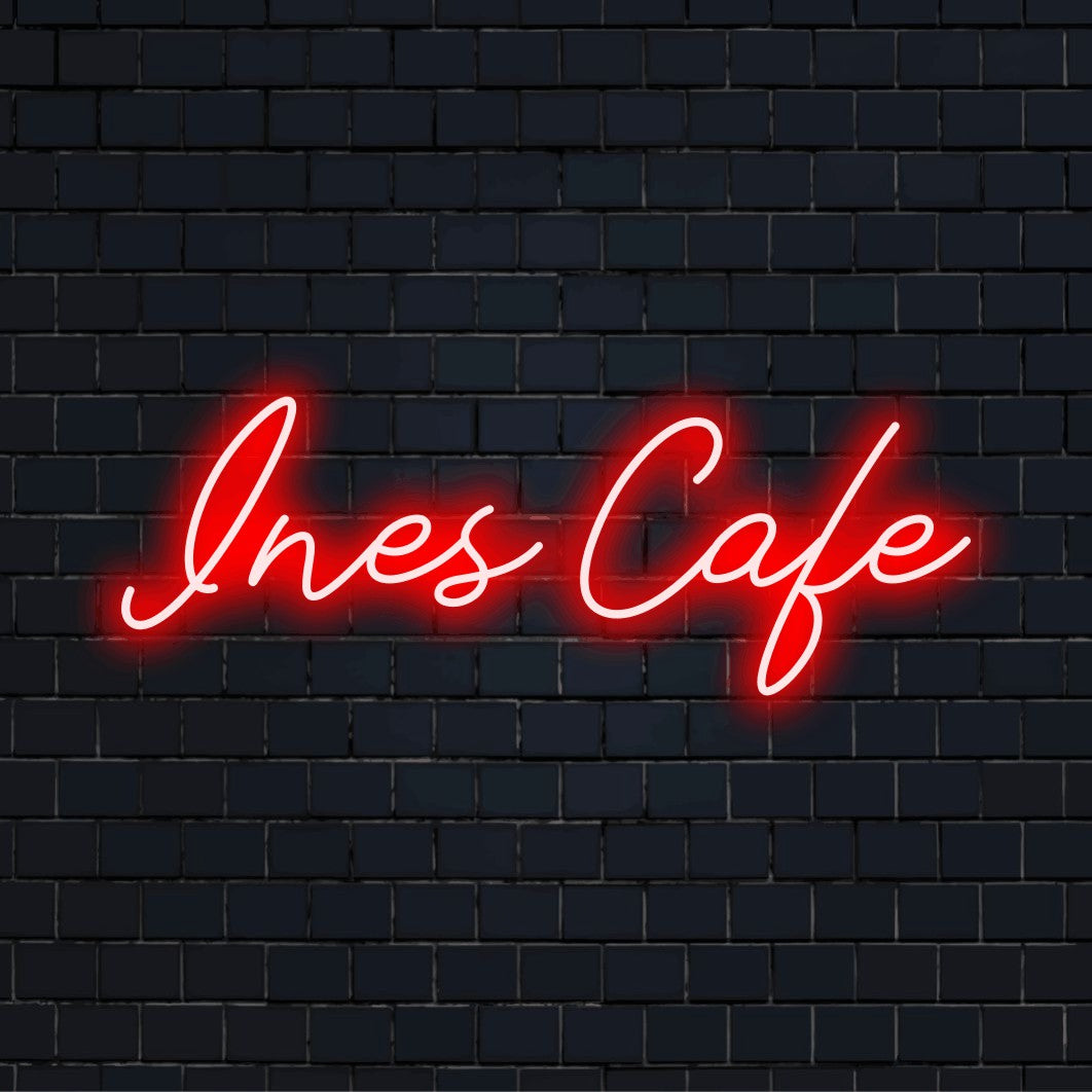 Ines Cafe Personalized Neon Light with soft neon glow on dark brick wall