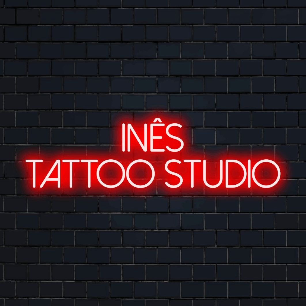 Ines Tattoo Studio Personalized Neon Light with glowing neon text on dark brick wall