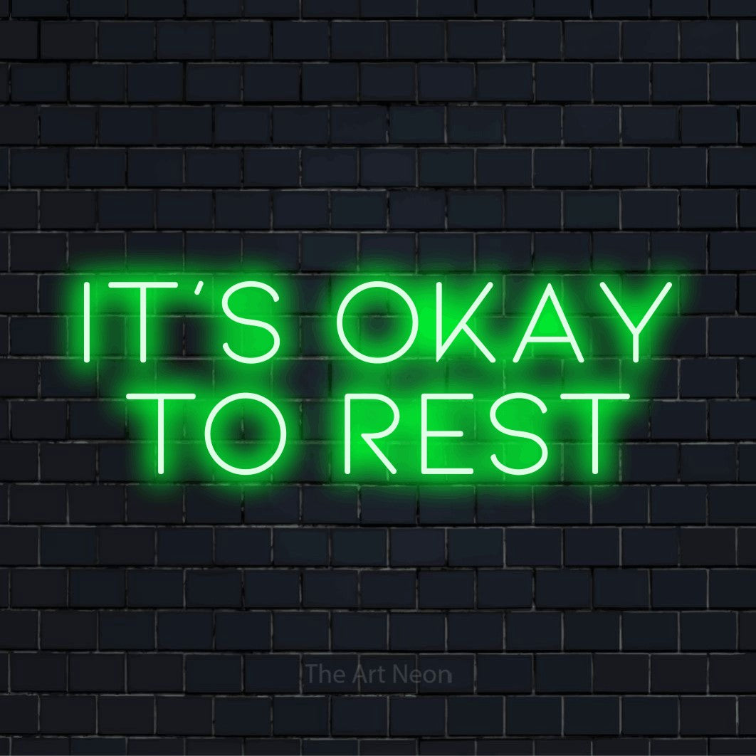 "It’s Okay To Rest" glowing LED neon sign on a black brick wall