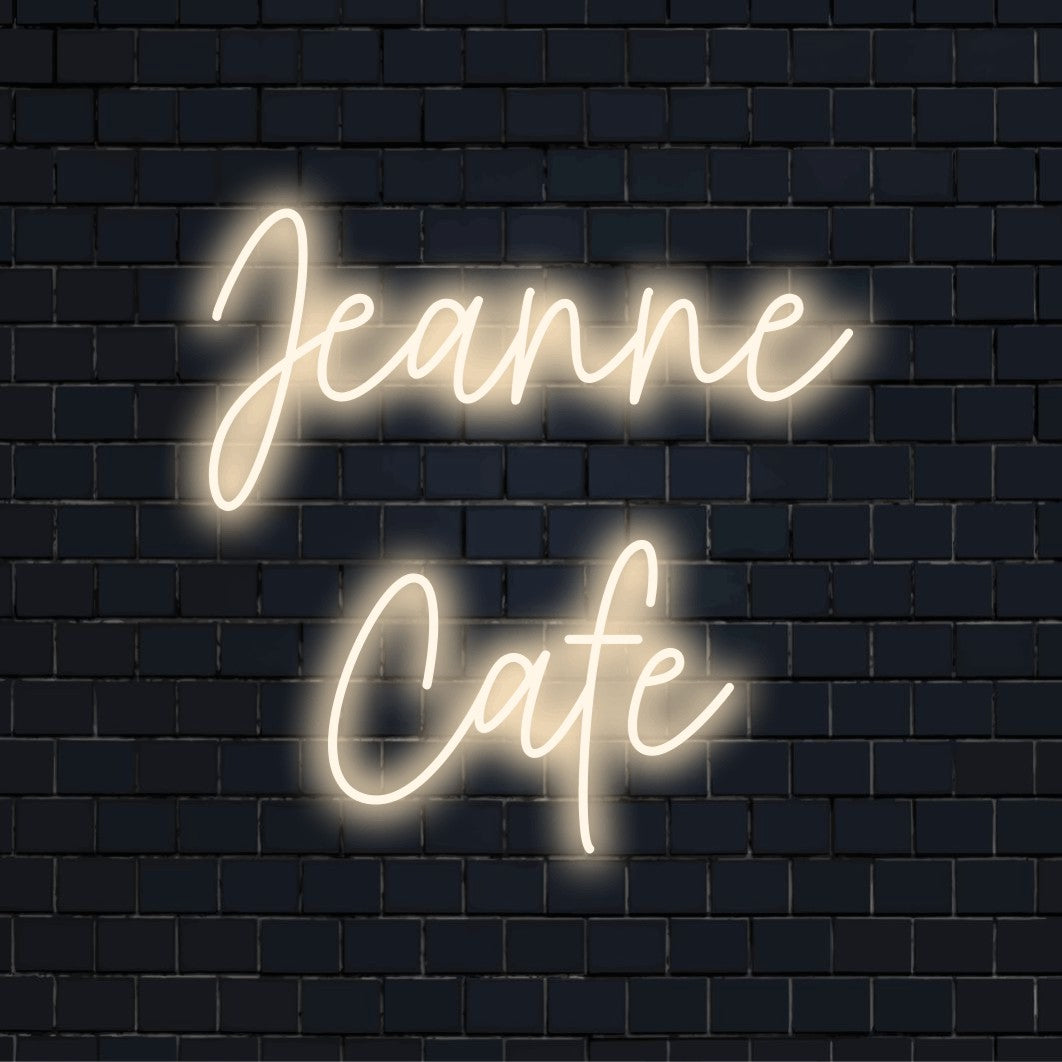 Jeanne Cafe Custom Name Neon Sign, bright neon lettering on black brick background