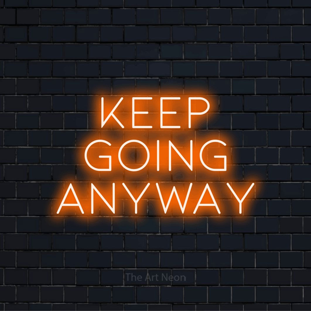 "Keep Going Anyway" neon text design on a black brick wall