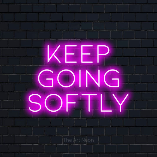 "Keep Going Softly" LED neon sign on a black brick wall
