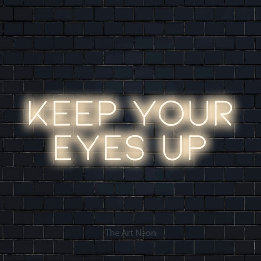 "Keep Your Eyes Up" LED neon sign on a black brick wall