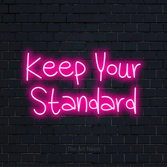 "Keep Your Standard" glowing LED neon sign on a black brick wall