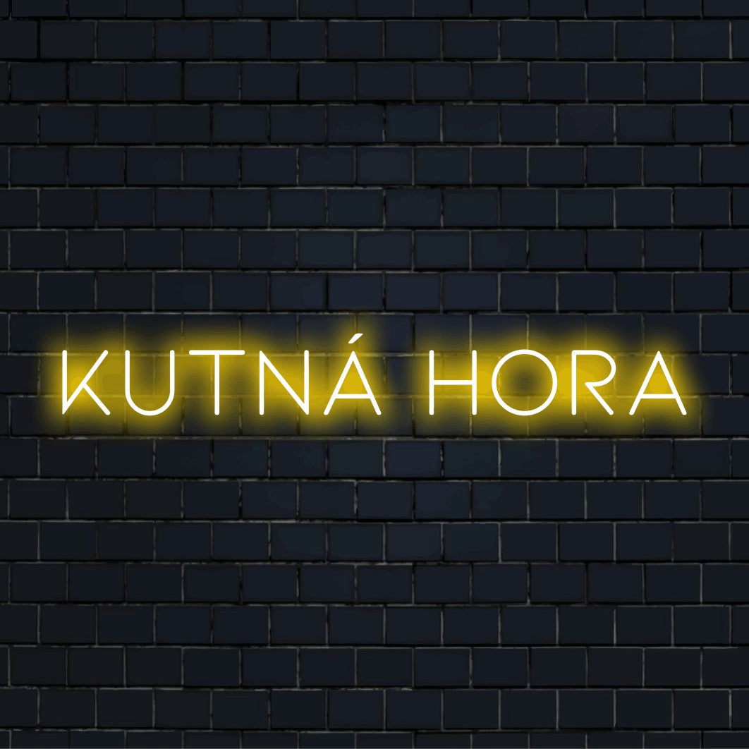 Kutn Hora Neon Sign, bright neon lettering against black brick wall