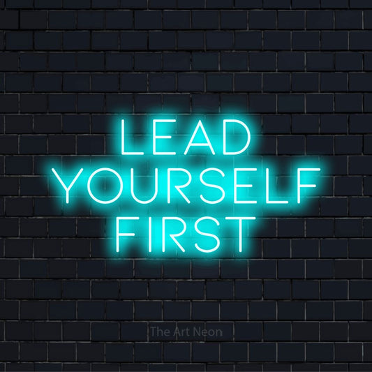 "Lead Yourself First" LED neon sign on a black brick wall