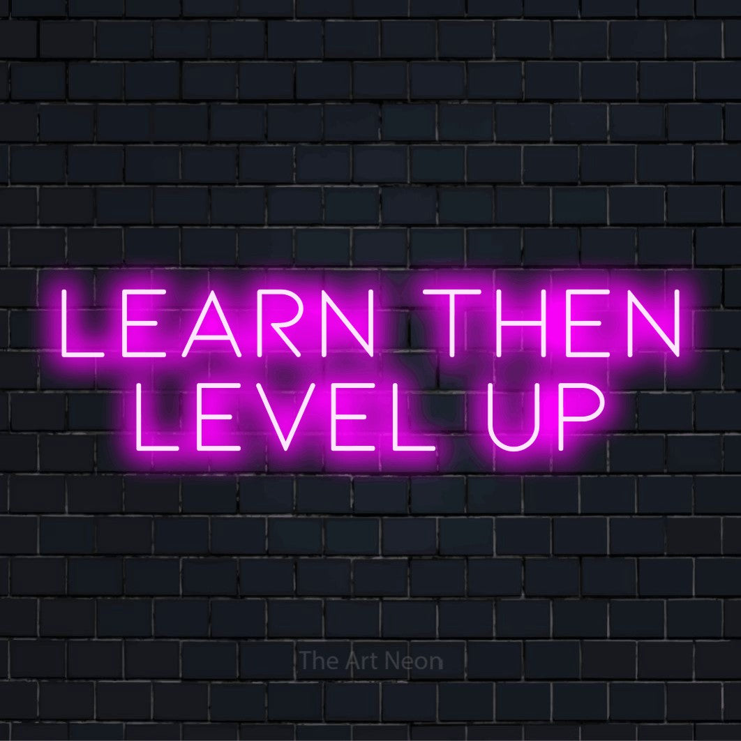 "Learn Then Level Up" LED neon sign on a black brick wall