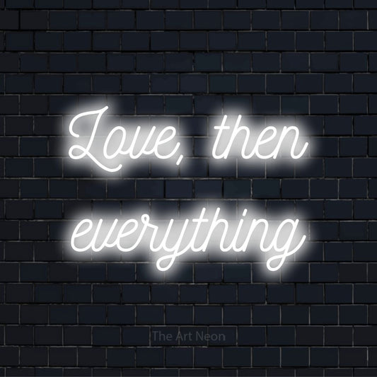 "Love, Then Everything" text design with neon effect on a black brick wall