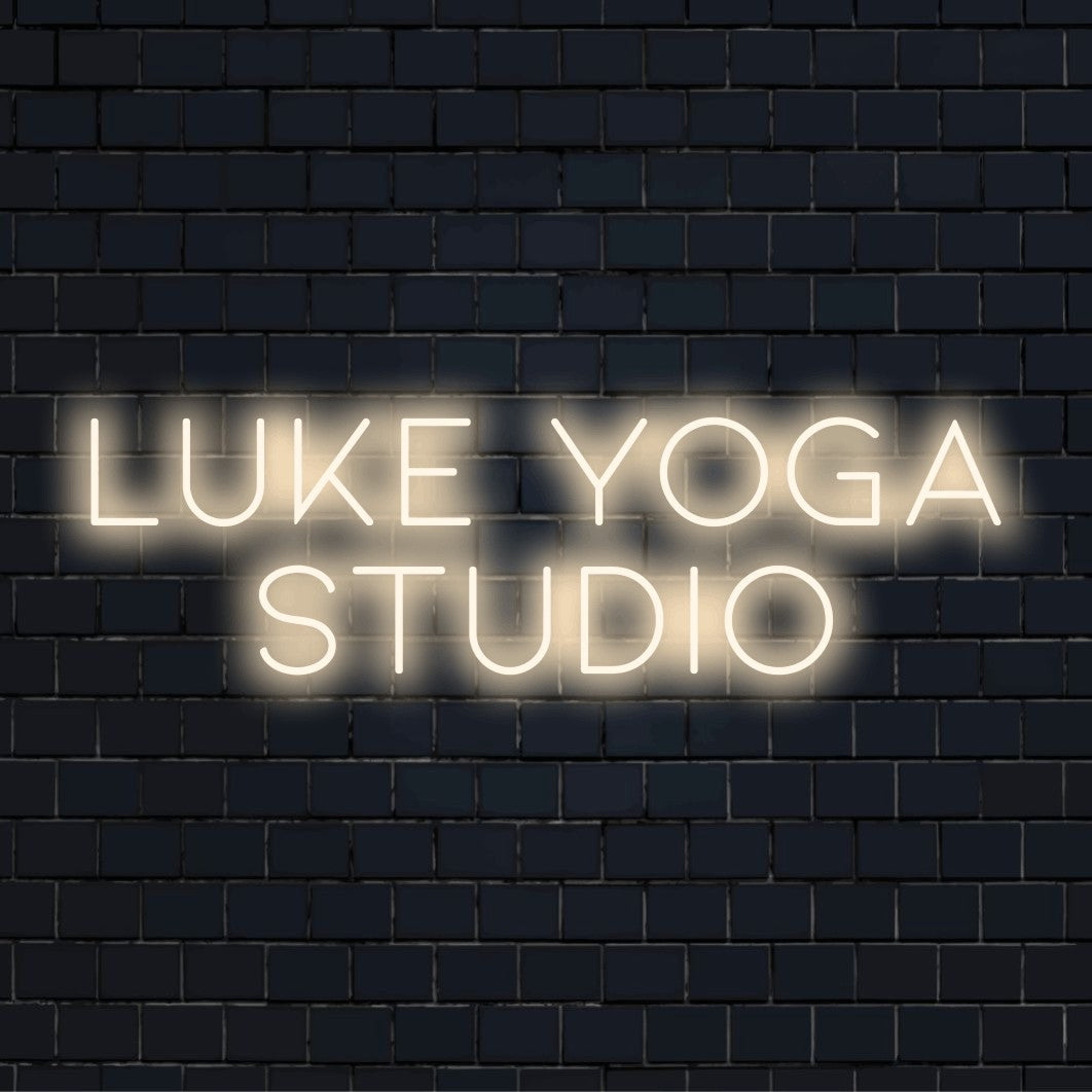 Luke Yoga Studio Personalized Neon Light with glowing wall decor on dark brick background