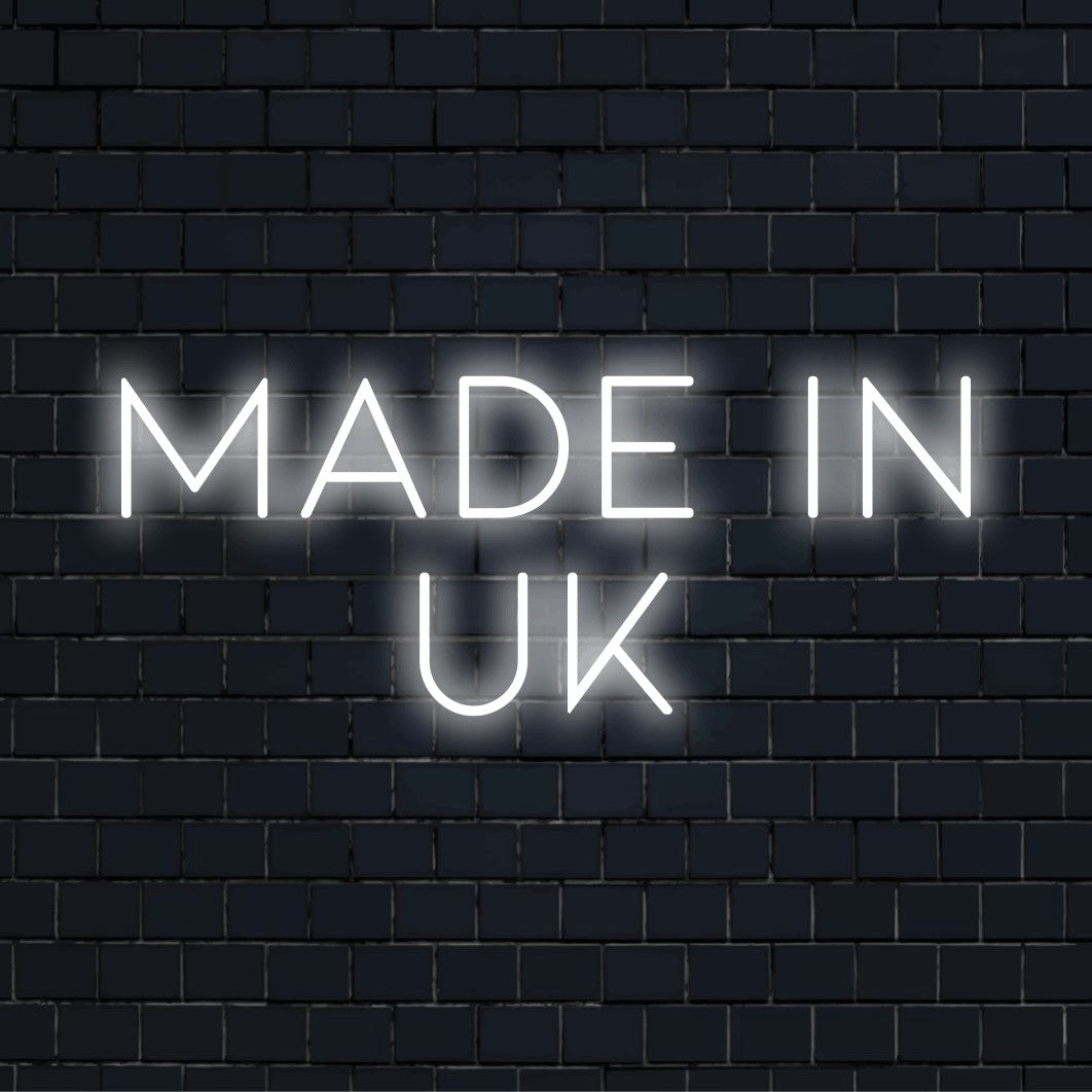 Made In Uk Neon Sign, neon text light against brick backdrop