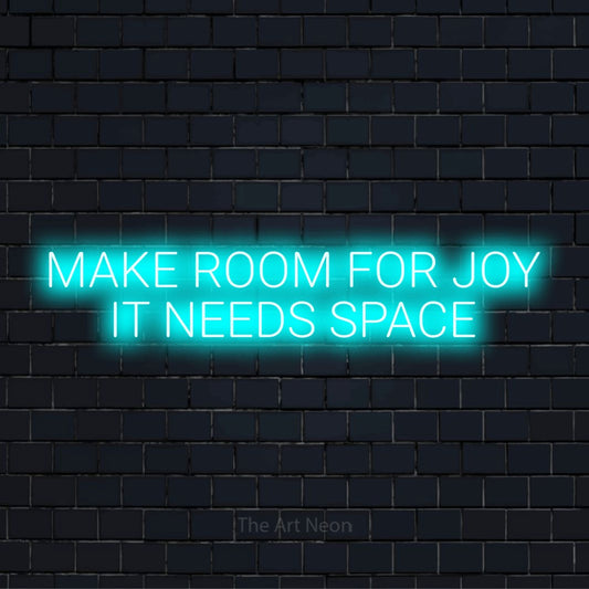 "Make Room For Joy It Needs Space" glowing LED neon sign on a black brick wall
