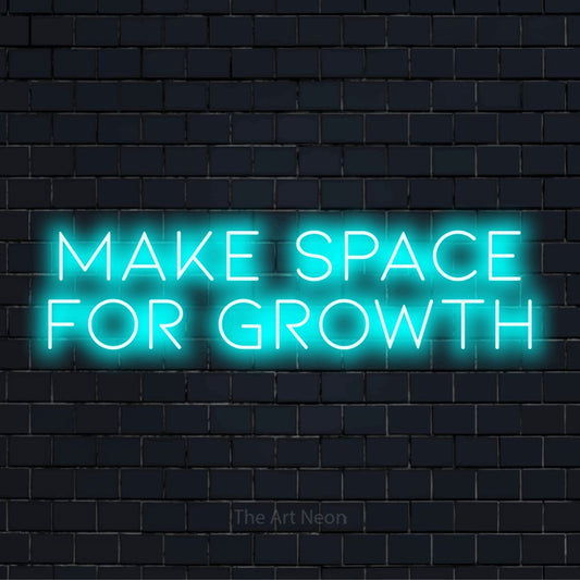 "Make Space For Growth" glowing LED neon sign on a black brick wall