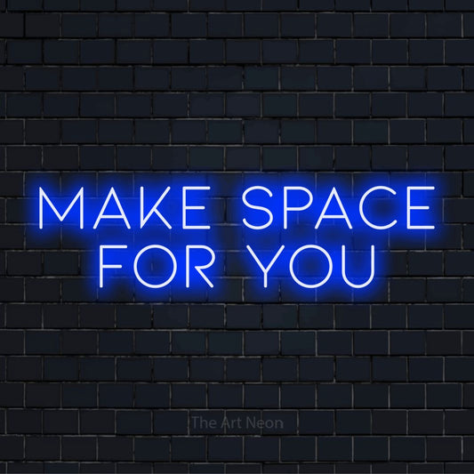 "Make Space For You" glowing LED neon sign on a black brick wall