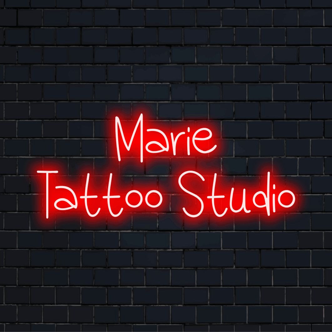 Marie Tattoo Studio Personalized LED Neon Sign, glowing neon text on dark brick background