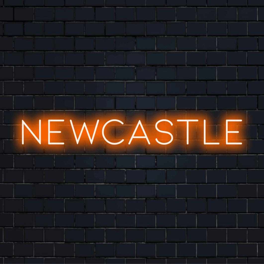 Newcastle Neon Sign, bright neon lettering against black brick wall