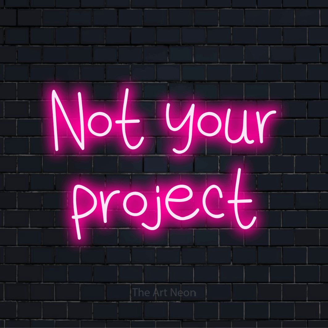 "Not Your Project" script-style LED neon sign on a black brick wall