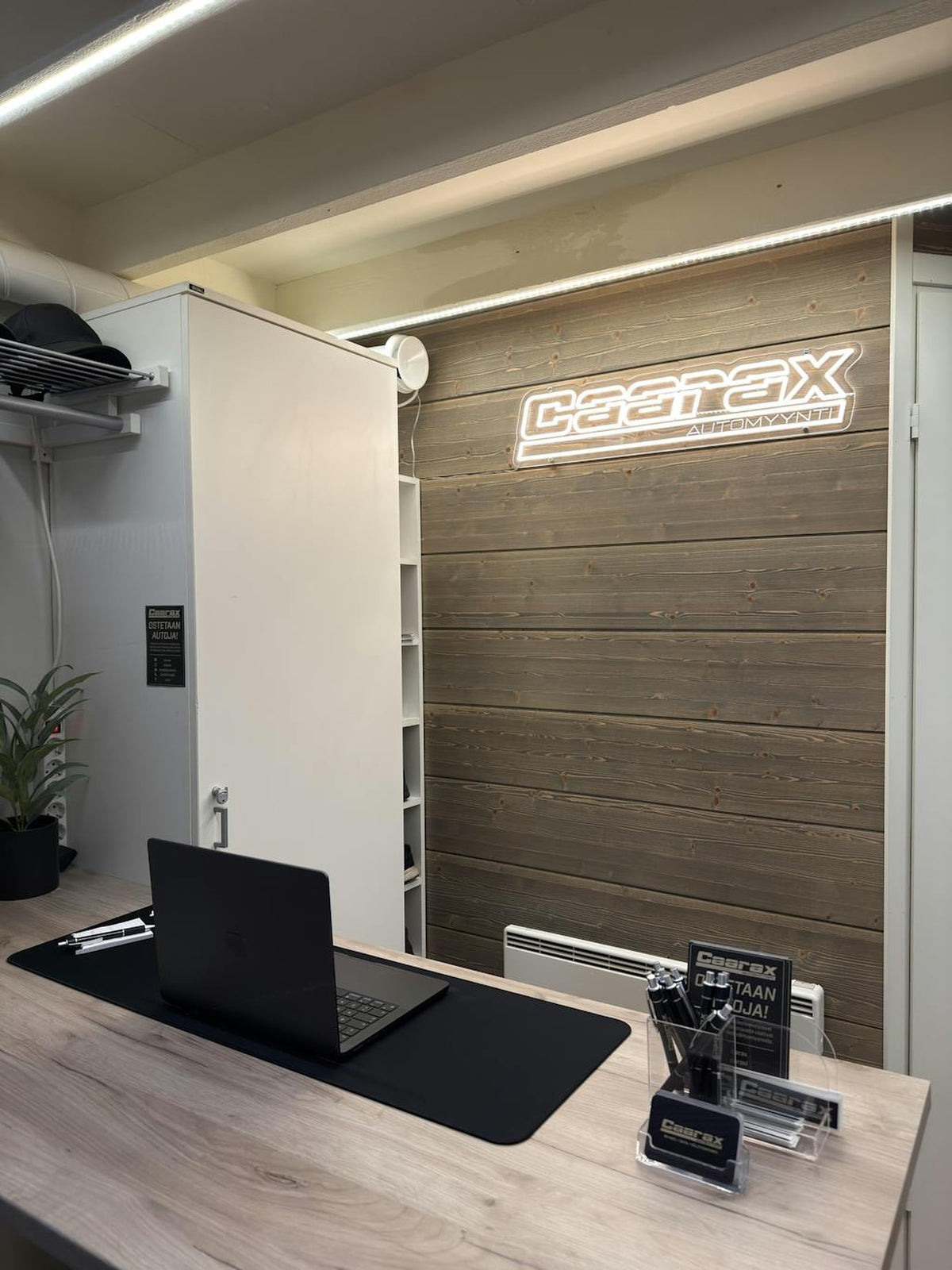 Company logo LED neon sign mounted on a wood reception wall
