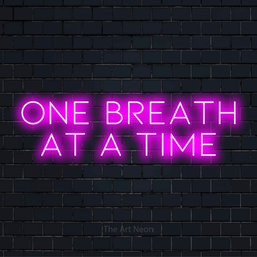 "One Breath At A Time" LED neon sign on a black brick wall