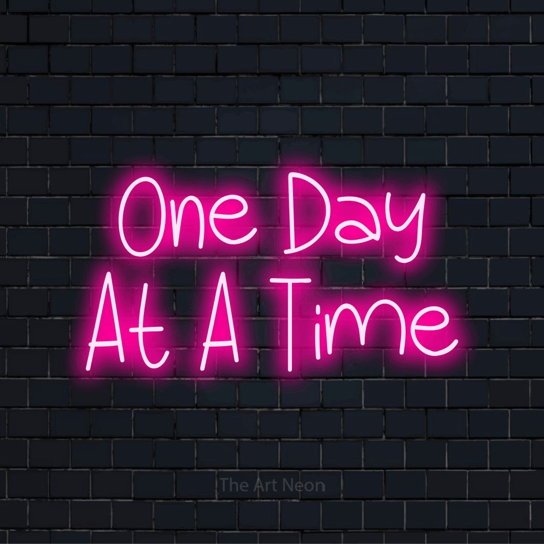 "One Day At A Time" neon text design on a black brick wall