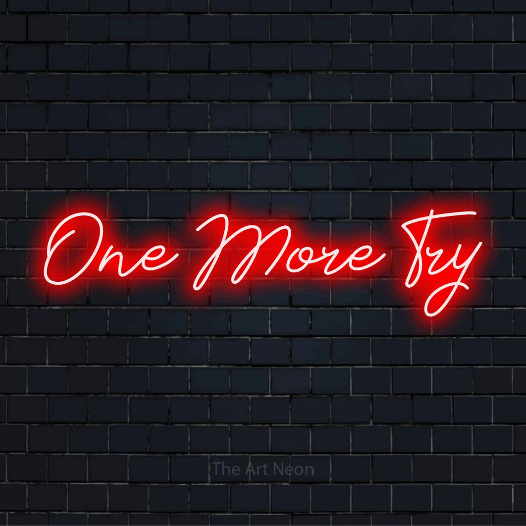 "One More Try" script-style LED neon sign on a black brick wall