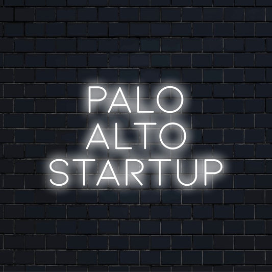 Palo Alto Startup Neon Sign, glowing lettering on dark brick wall
