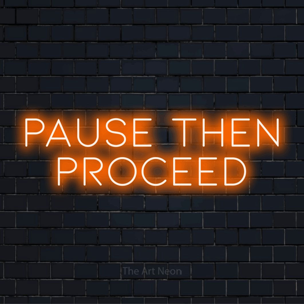 "Pause Then Proceed" LED neon sign on a black brick wall