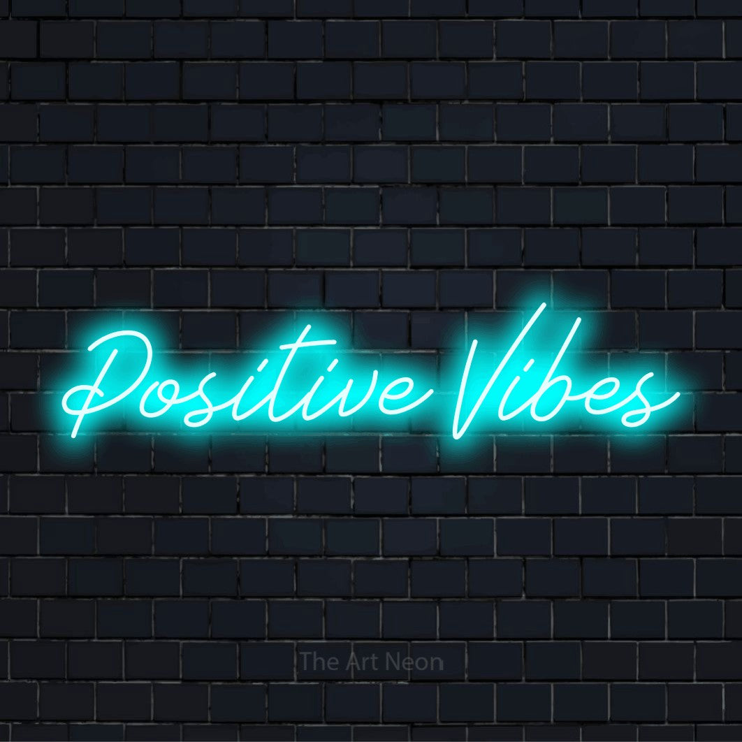 "Positive Vibes" neon text design on a black brick wall