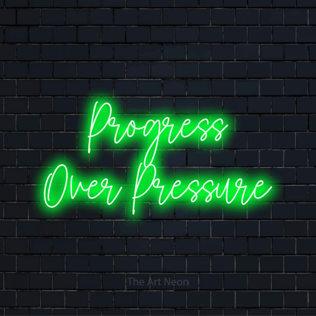 "Progress Over Pressure" script-style LED neon sign on a black brick wall
