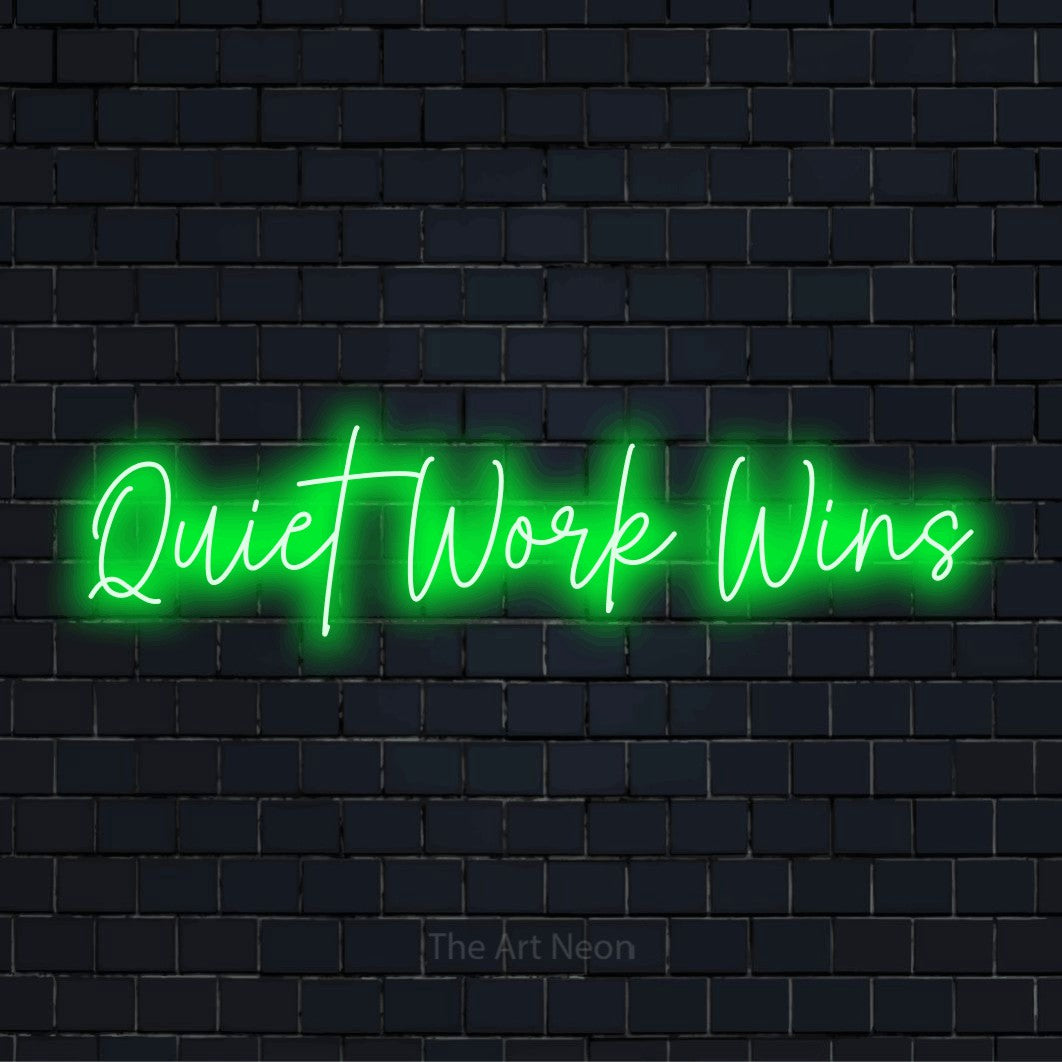 "Quiet Work Wins" glowing LED neon sign on a black brick wall