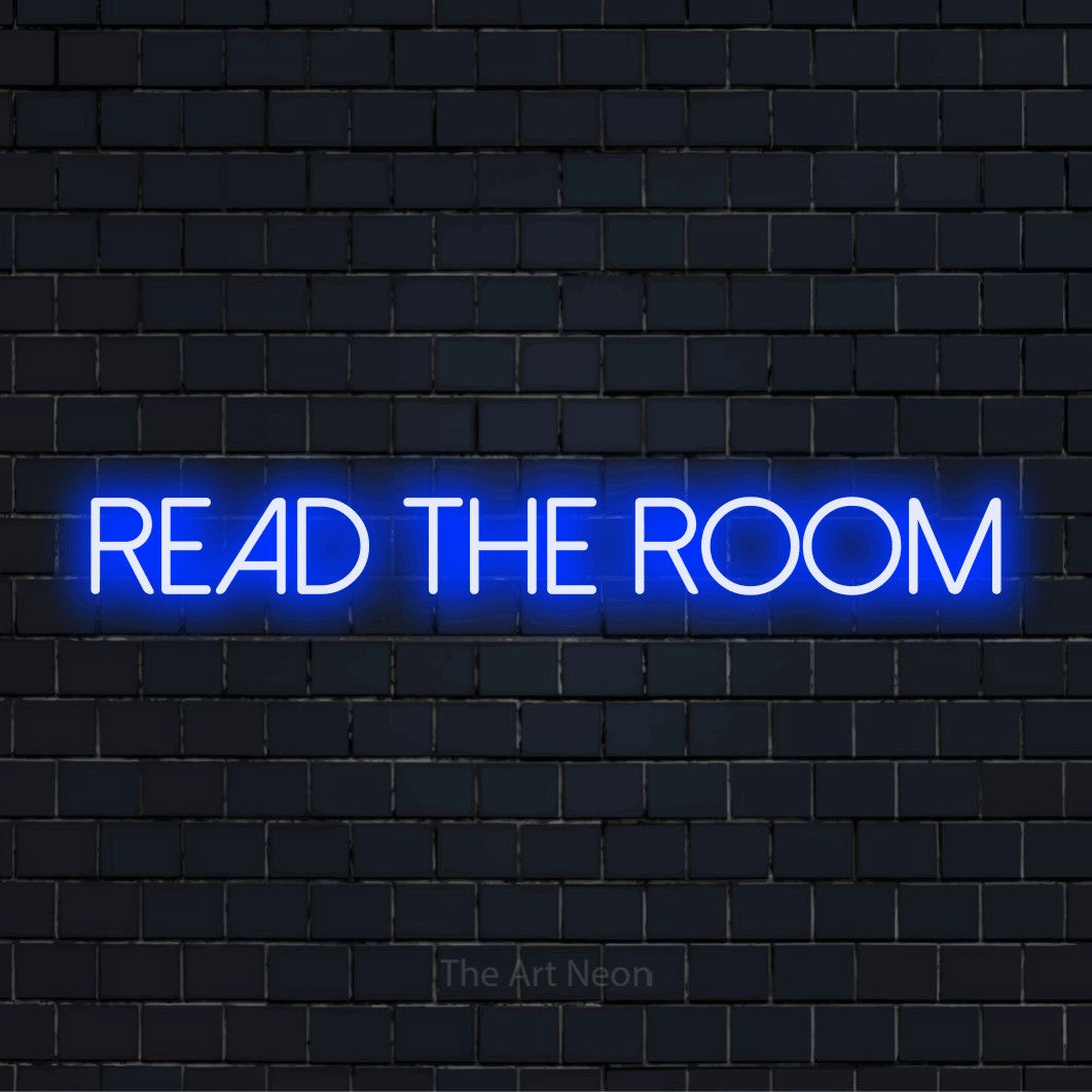 "Read The Room" glowing LED neon sign on a black brick wall