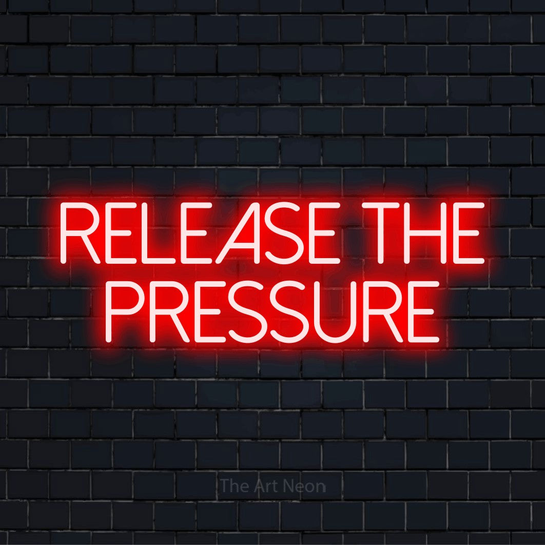 "Release The Pressure" glowing LED neon sign on a black brick wall
