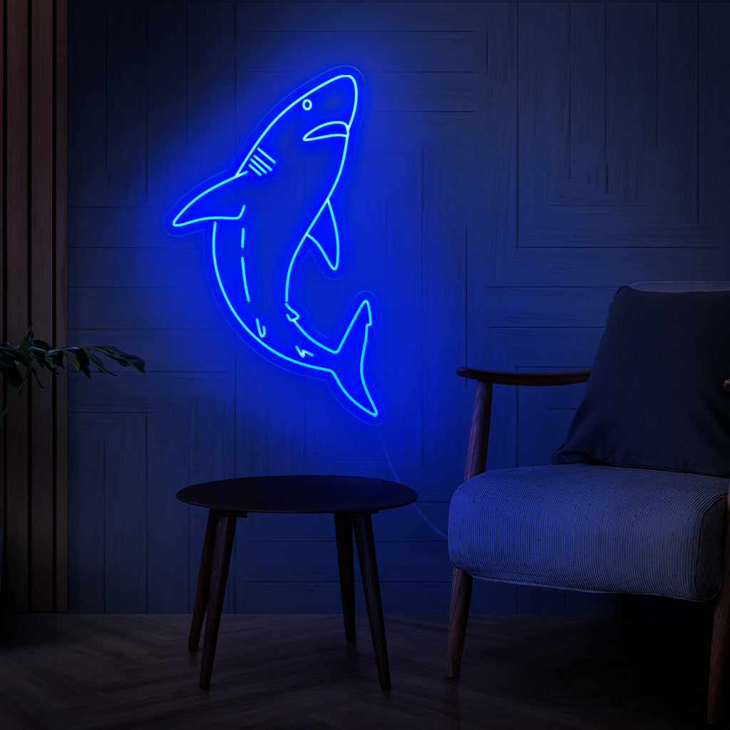 O letreiro de neon de tubarão é uma adição ousada à decoração com tema oceânico, iluminando com uma luz forte e cativante.