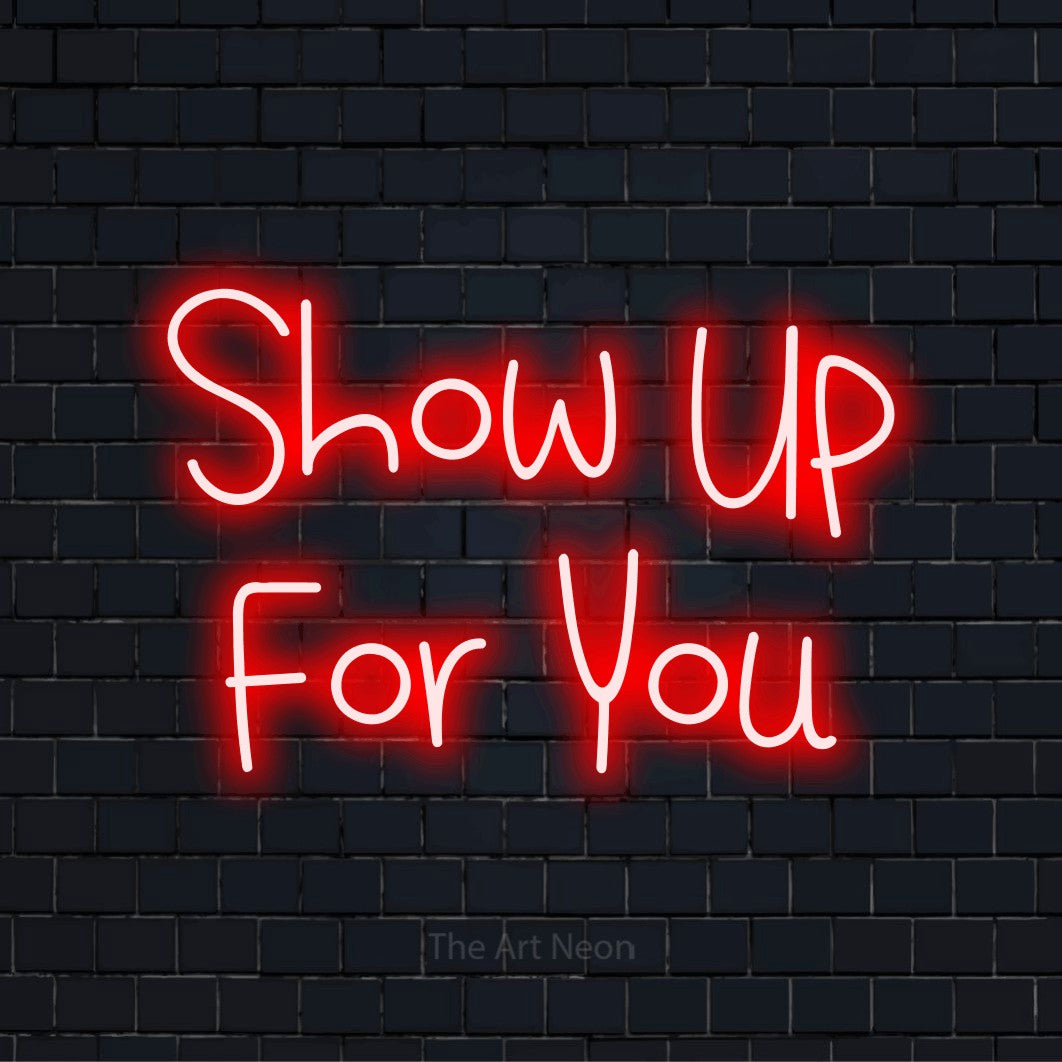 "Show Up For You" glowing LED neon sign on a black brick wall