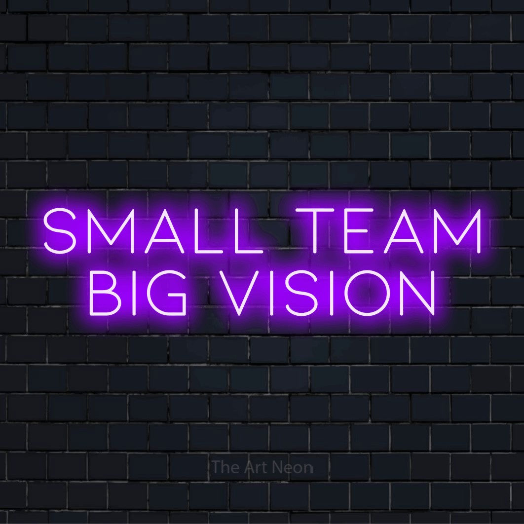 "Small Team Big Vision" LED neon sign on a black brick wall