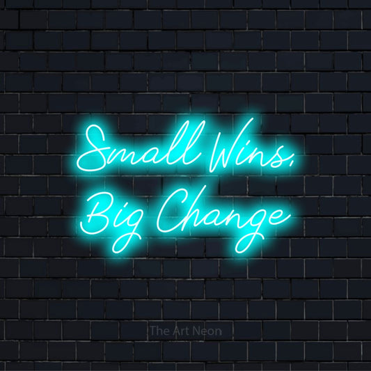 "Small Wins, Big Change" glowing LED neon sign on a black brick wall