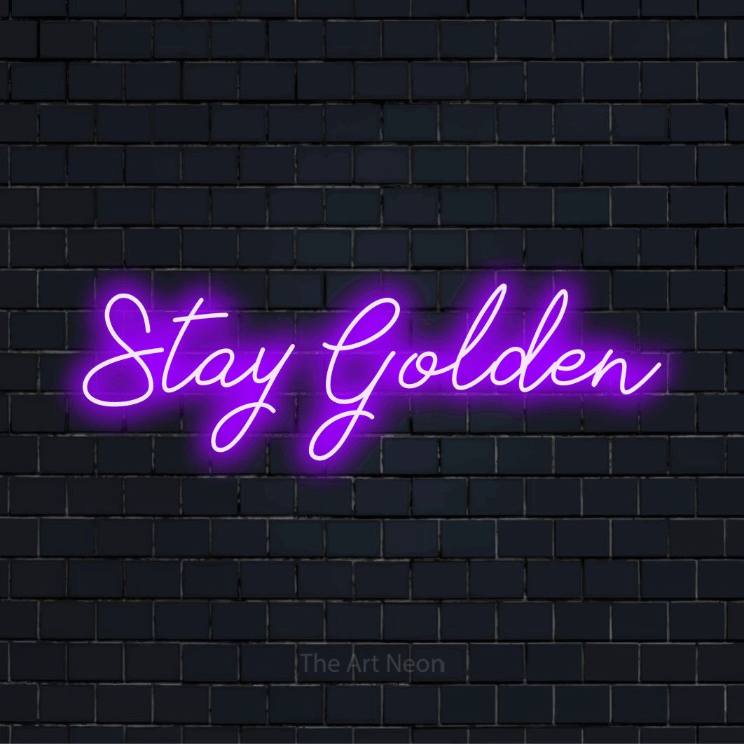 "Stay Golden" neon text design on a black brick wall