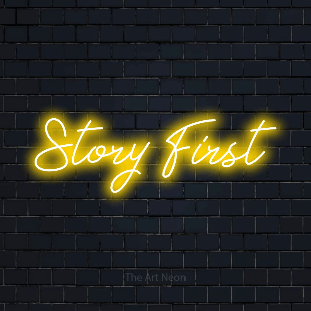 "Story First" glowing LED neon sign on a black brick wall