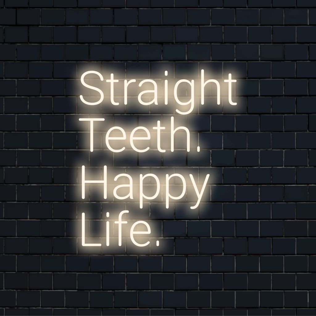 Straight Teeth Happy Life Neon Sign, bright neon lettering on dark brick background