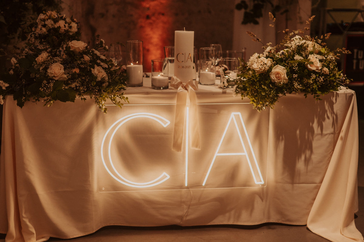 Warm-white C and A initials LED neon displayed on a table for a wedding celebration.