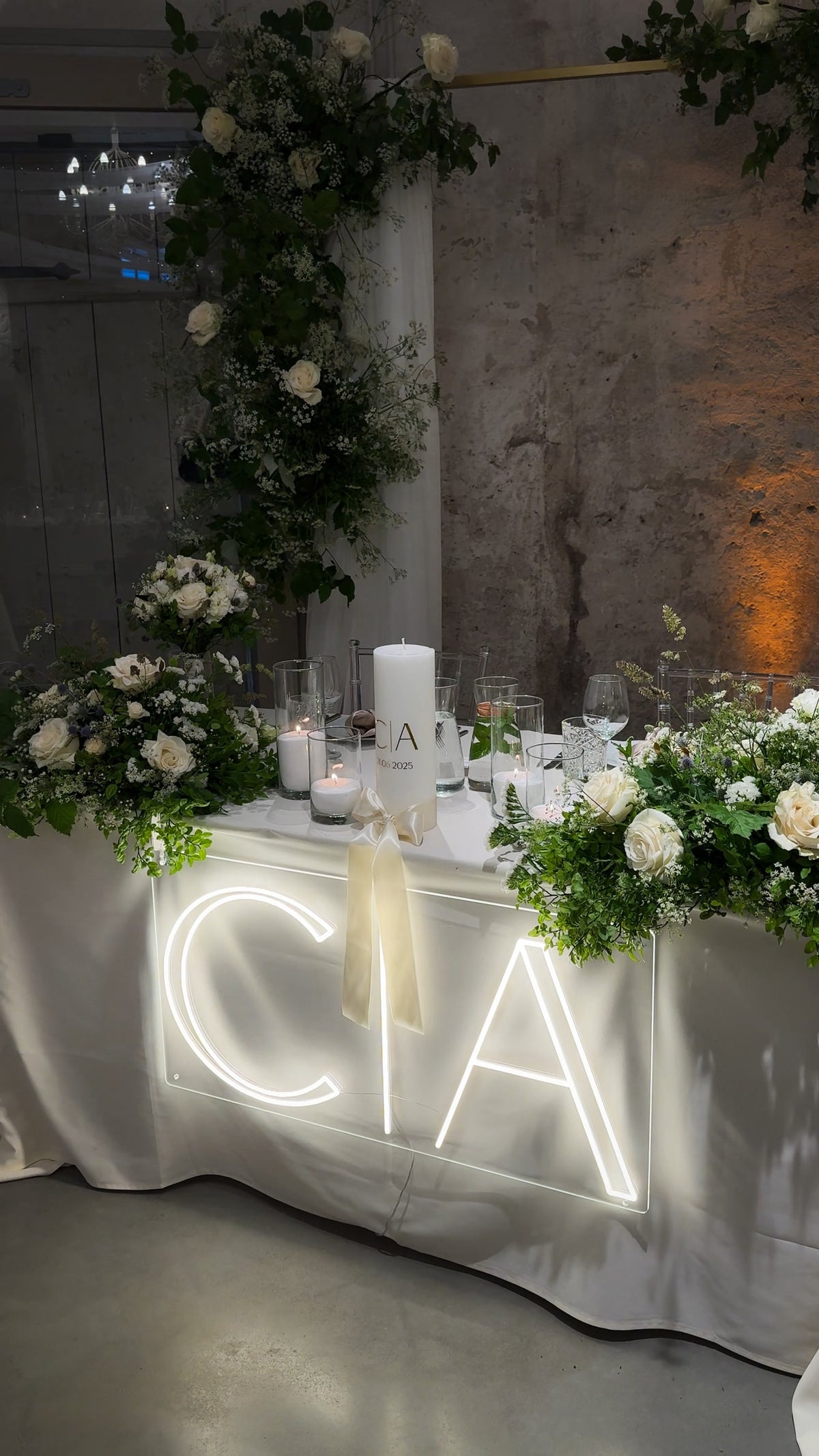 Warm-white C and A initials LED neon displayed on a table for a wedding celebration.