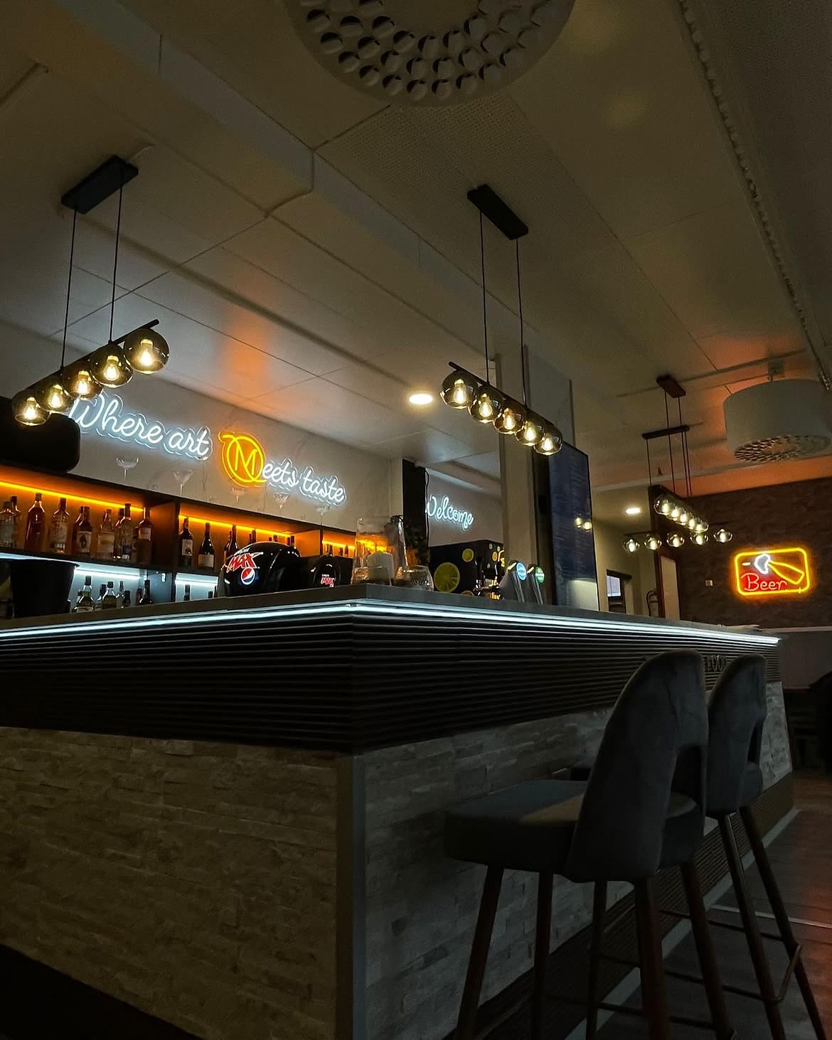 Green LED neon restaurant sign above booth seating in a colourful dining interior