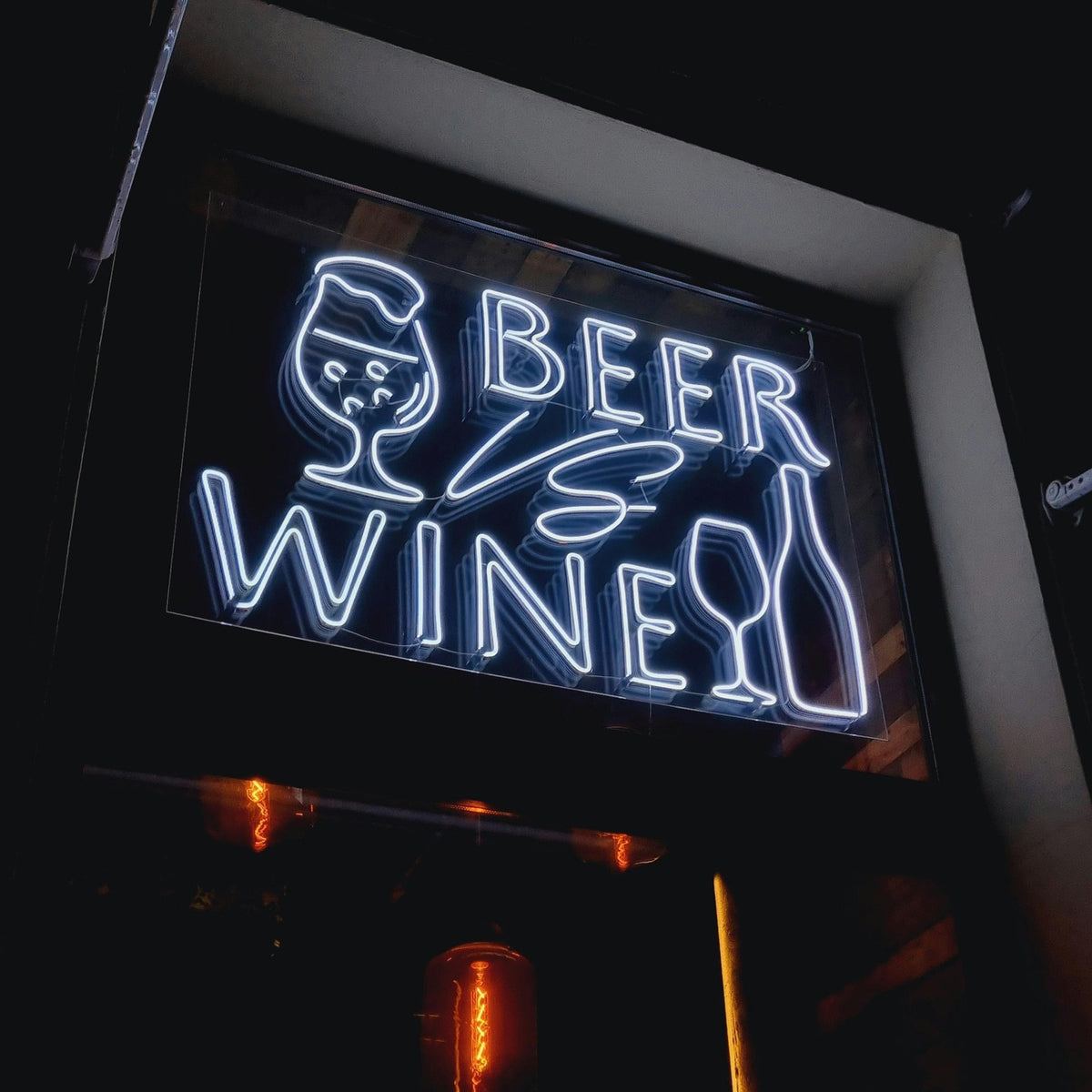 White Beer vs Wine LED neon sign with beer glass and wine bottle artwork, installed in a window