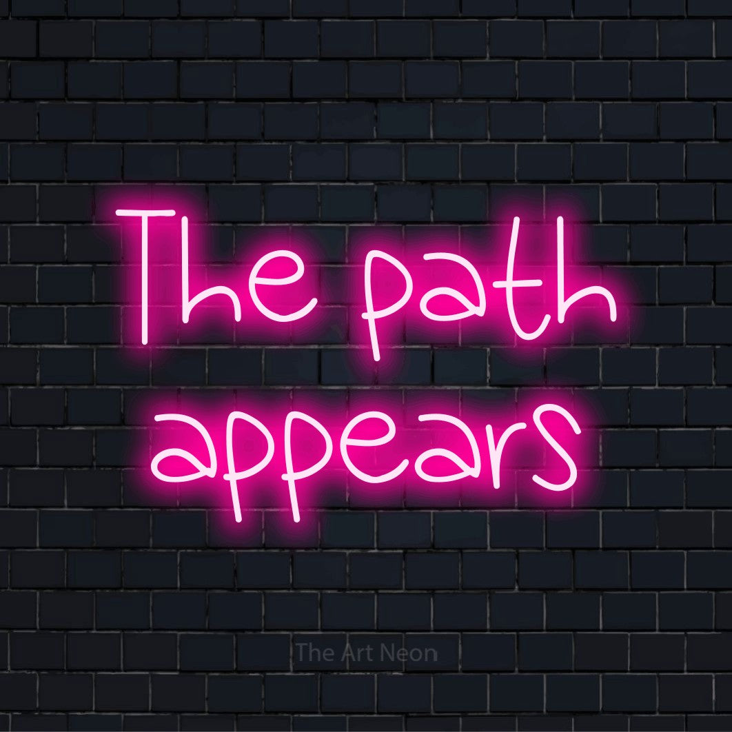 "The Path Appears" script-style LED neon sign on a black brick wall