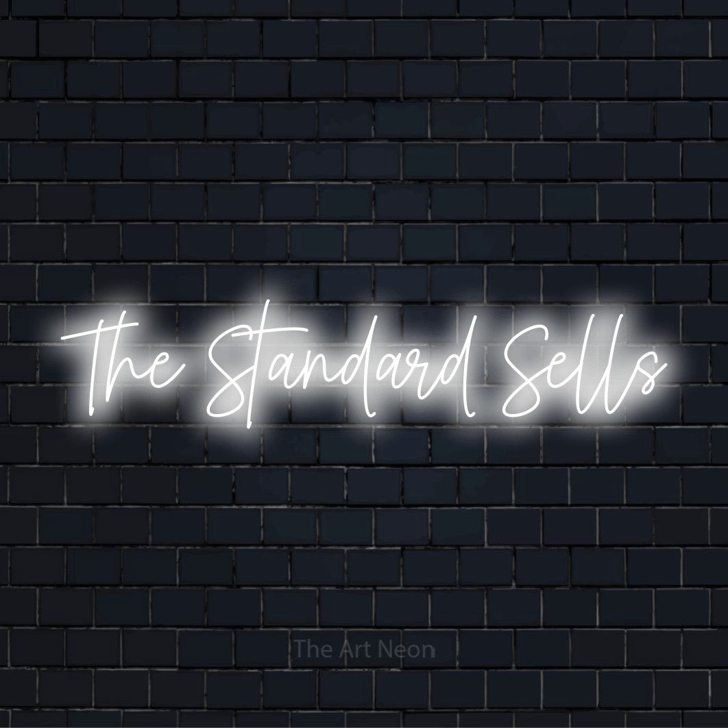 "The Standard Sells" neon text design on a black brick wall