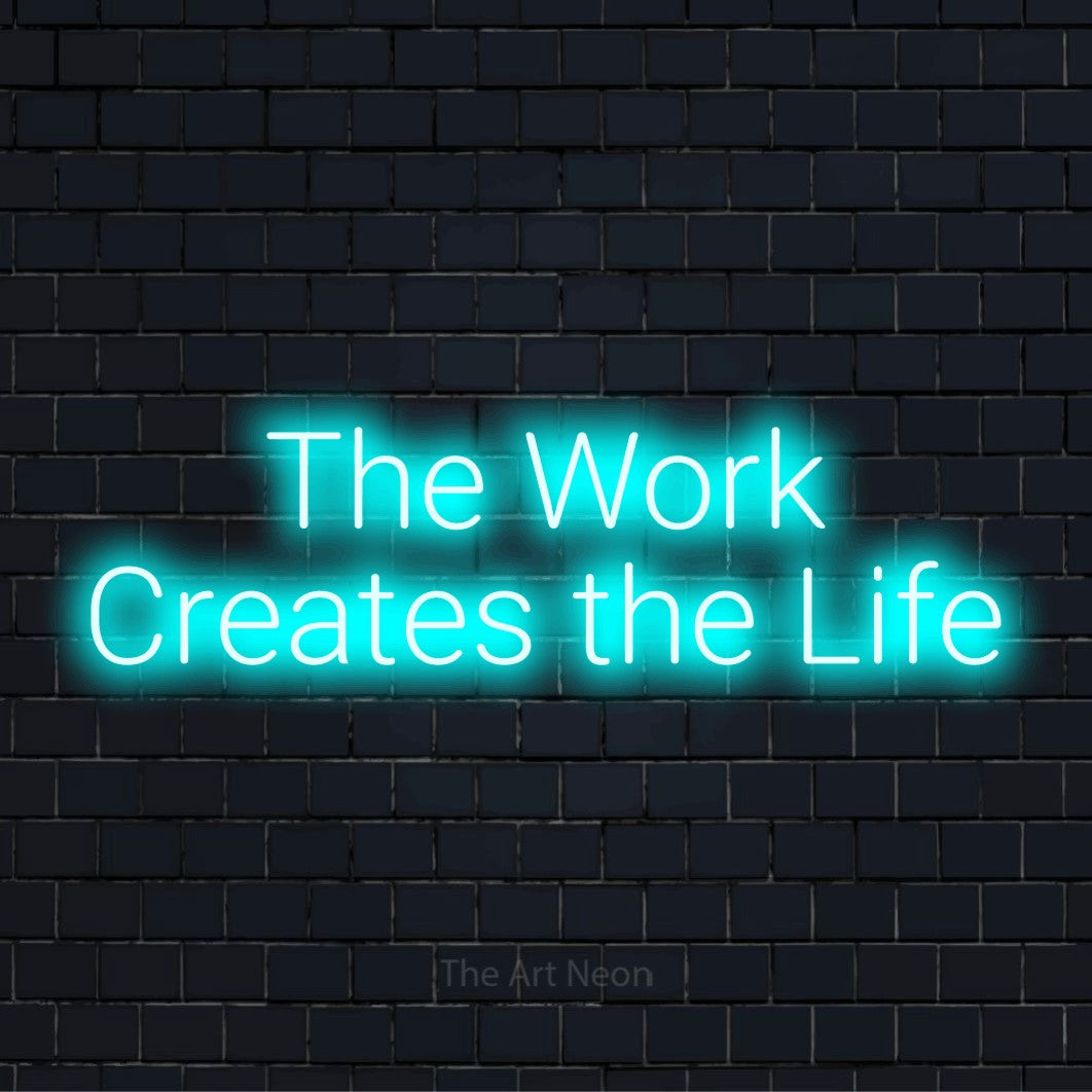 "The Work Creates The Life" LED neon sign on a black brick wall